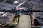 U.S. Army Spc. Kaitlin Cavanaugh and Sgt. Omar Sewell conduct maintenance on the forward rotor of a CH-47 Chinook helicopter, which was battle damaged from a hard landing while serving in Iraq, in the maintenance bay of the Connecticut National Guard's 1109th Theater Aviation Support Maintenance Group in Groton, Conn. June 22, 2021. The Theater Aviation Support Maintenance Group recovered this helicopter from Kuwait and performed a complete overhaul of the aircraft to get it back into the Army's operational fleet. Photo by Timothy Kloster.