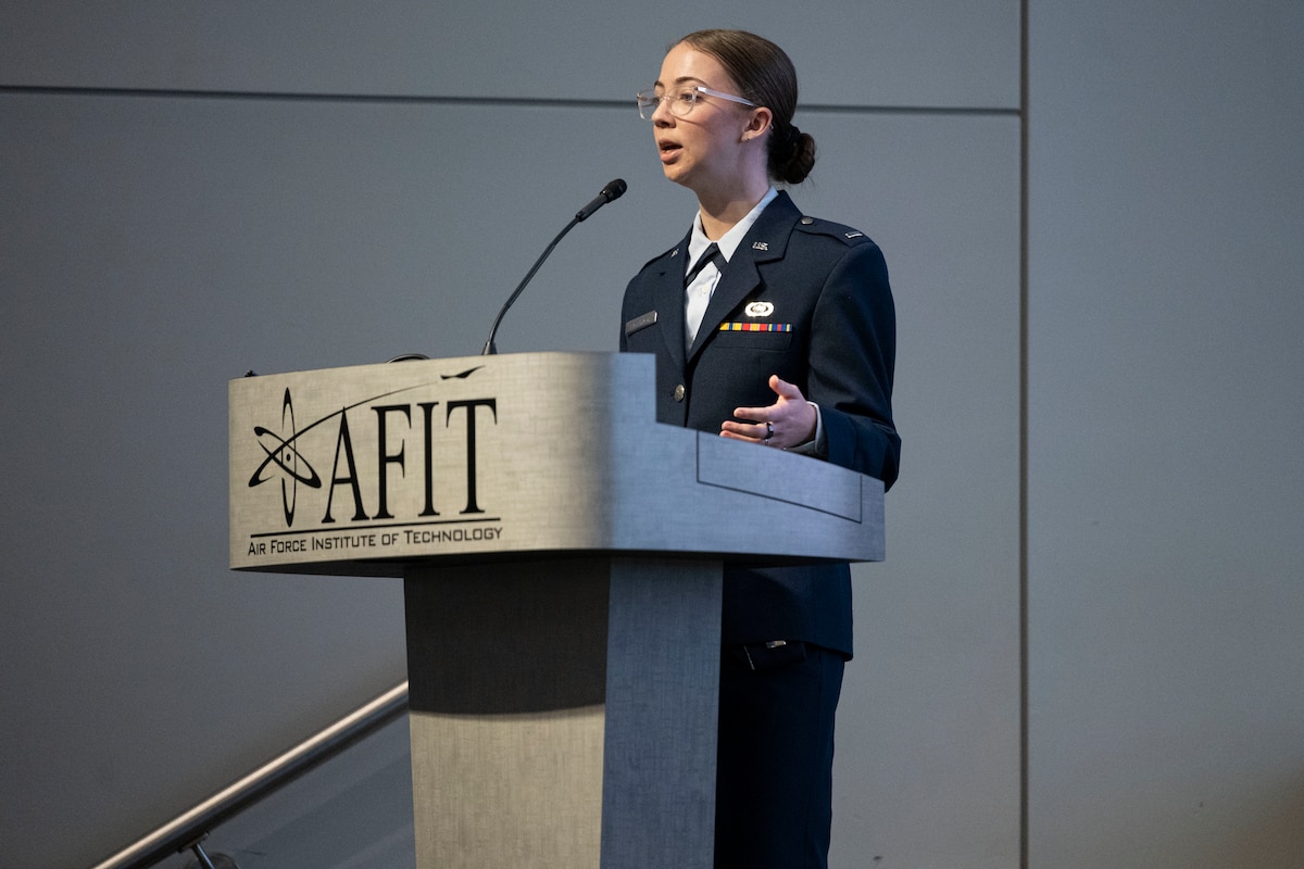 1st Lt. Adrianna Blenkush stands at a podium speaking at a conference.