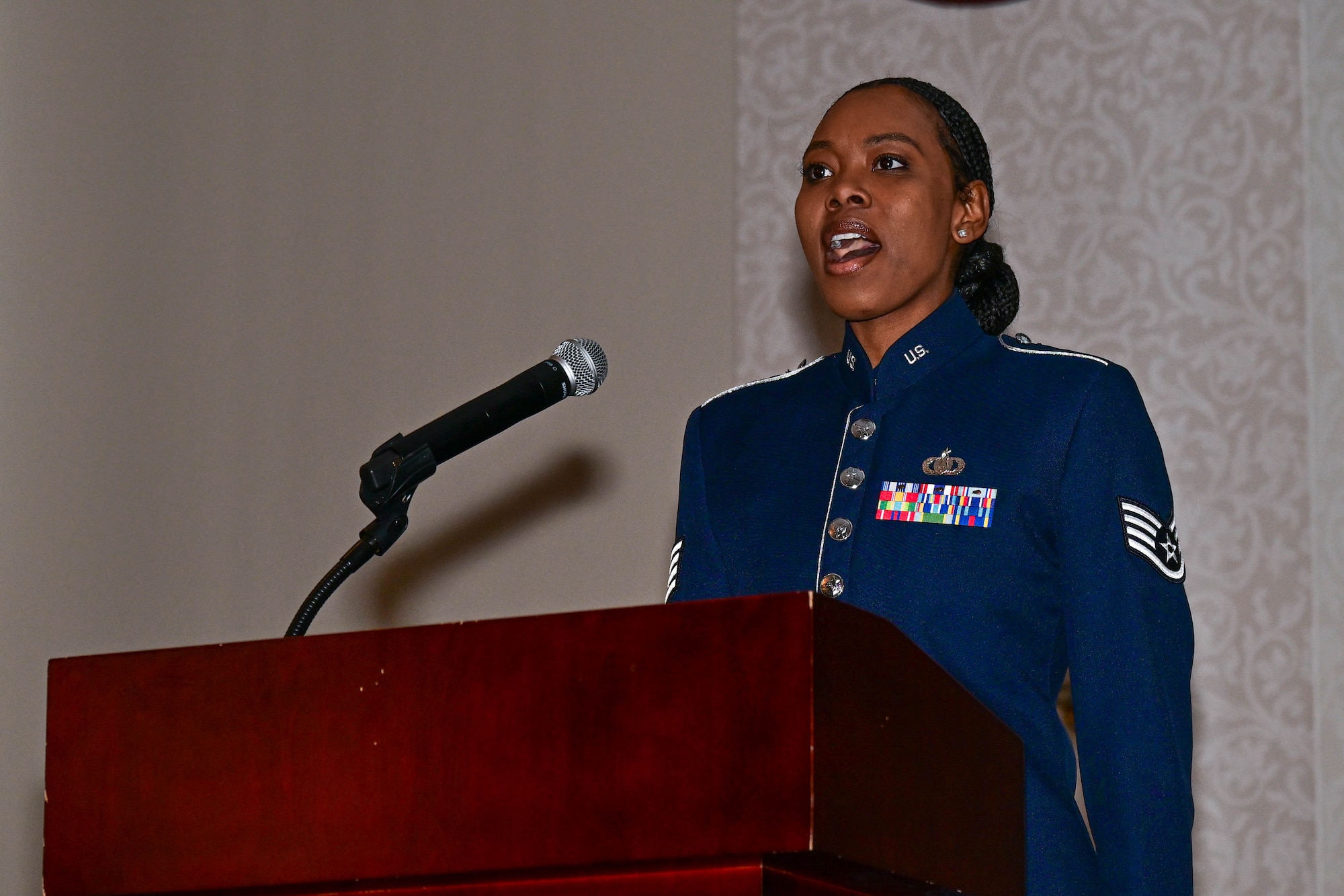 U.S. Air Force Staff Sgt. Melan Smart singing at a podium.