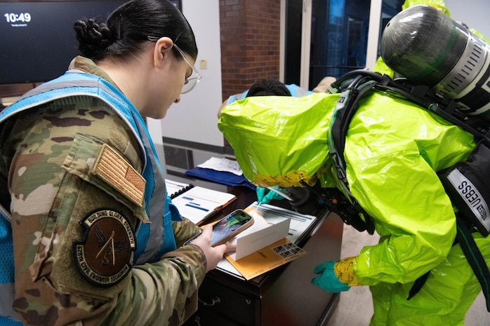 A photo of a woman in a blue vest assessing the Emergency Management Team.