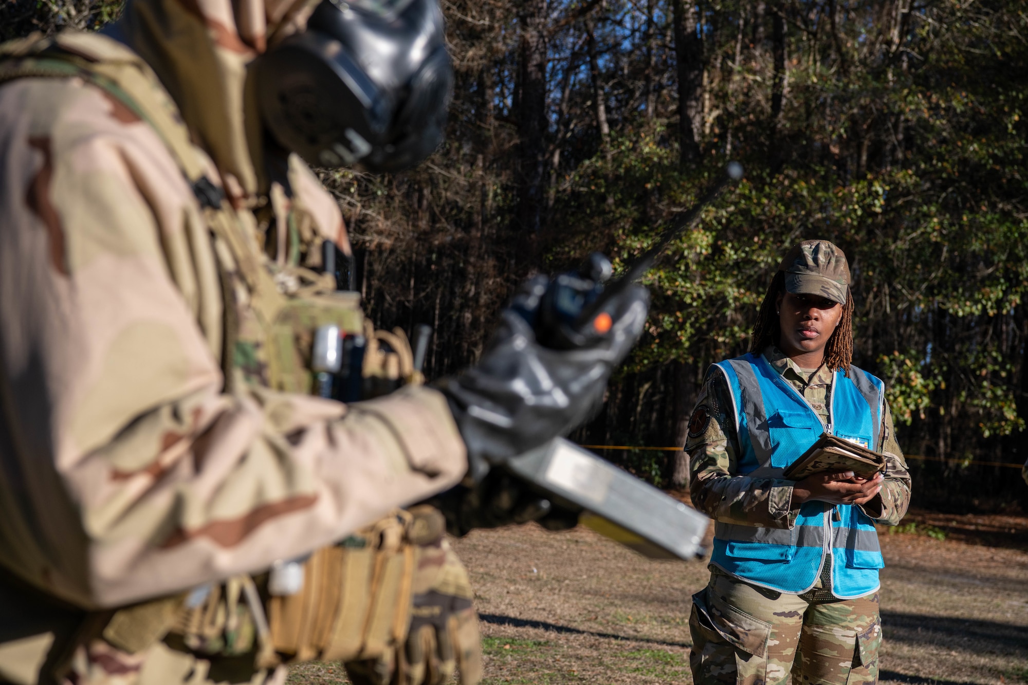 A photo of a man in a blue vest standing outside.