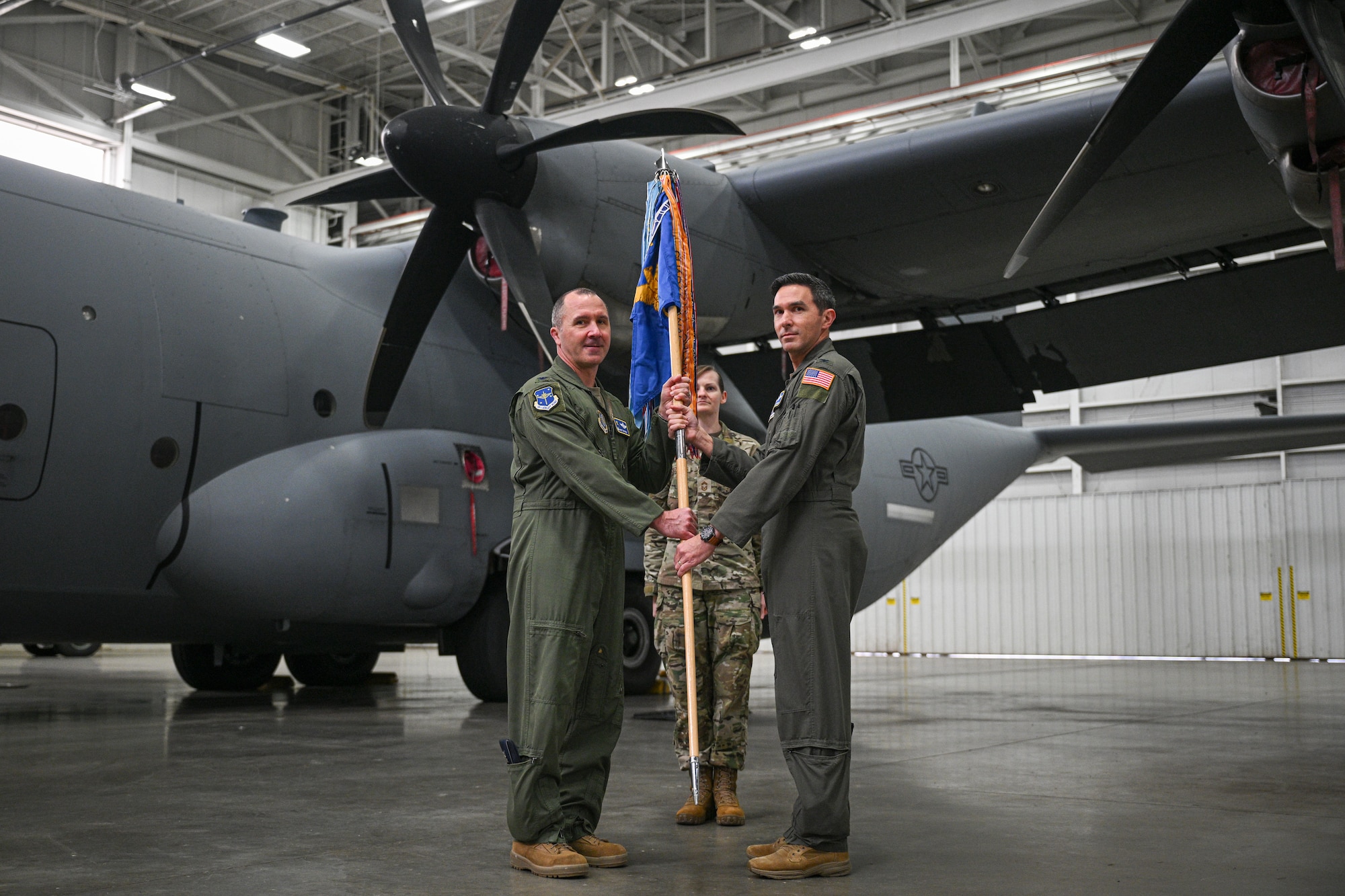 U.S. Air Force Col. Bret Echard, 19th Airlift Wing and installation commander, presents Col. Christopher Welch, 19th Operations Group commander, with the ceremonial guidon during a reactivation ceremony, Jan. 23, 2026, at Little Rock Air Force Base, Arkansas. The decision to return to the original group structure reflects guidance from the Chief of Staff of the Air Force and aims to reduce change fatigue while strengthening commander-led readiness.