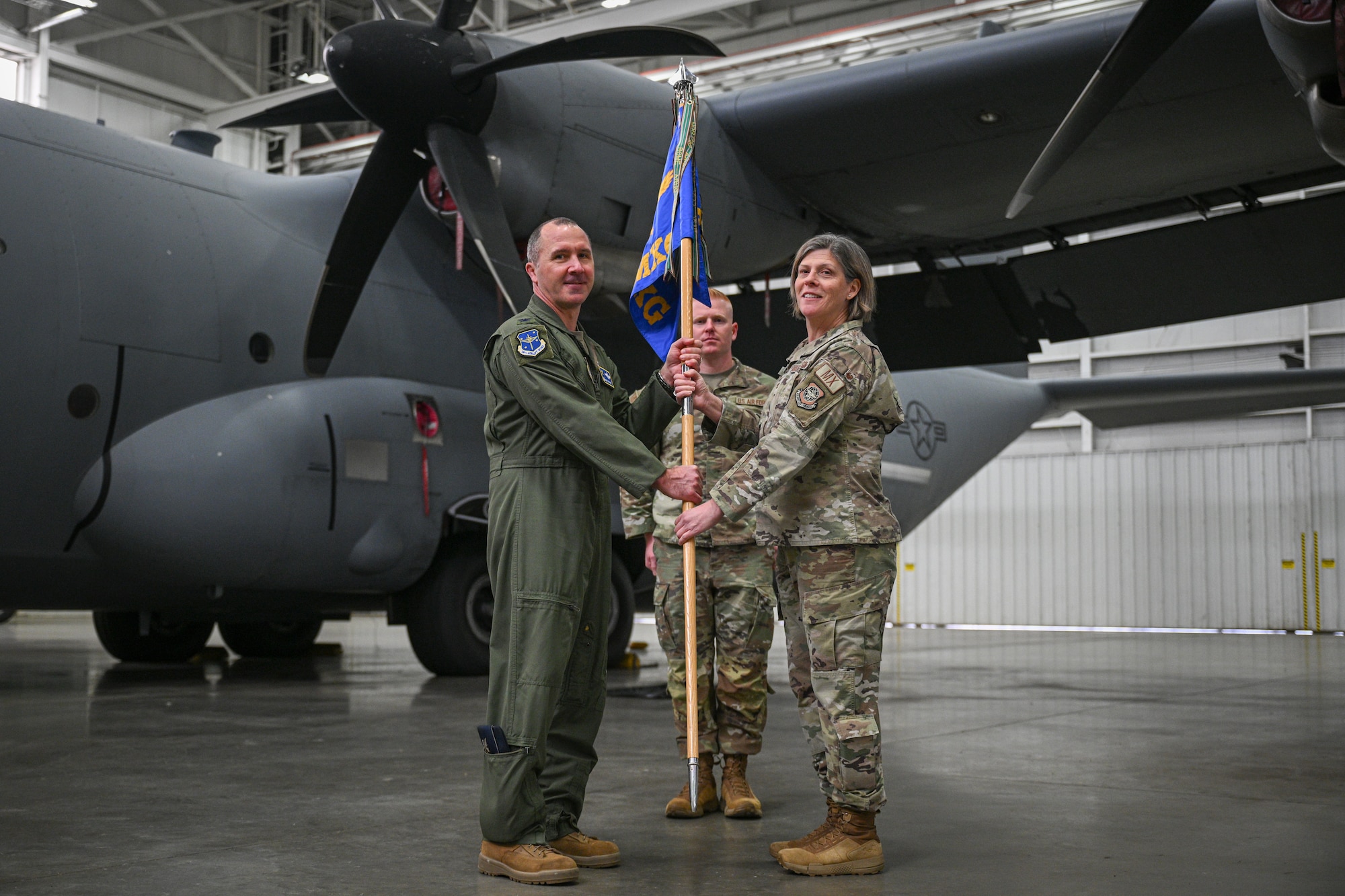 U.S. Air Force Col. Bret Echard, 19th Airlift Wing and installation commander, presents Col. Amanda Sheets, 19th Maintenance Group commander, with the ceremonial guidon during a reactivation ceremony, Jan. 23, 2026, at Little Rock Air Force Base, Arkansas. The decision to return to the original group structure reflects guidance from the Chief of Staff of the Air Force and aims to reduce change fatigue while strengthening commander-led readiness.