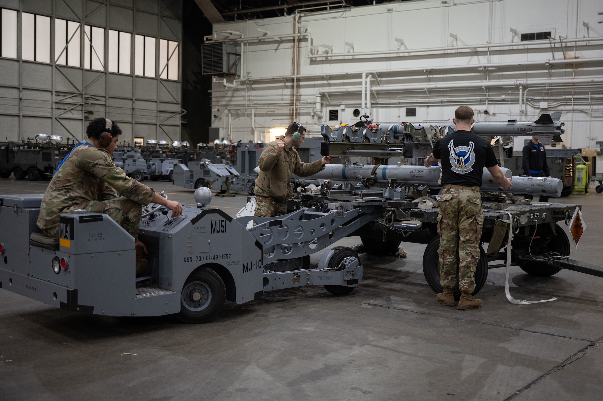 U.S. Air Force Airman 1st Class Jordyn Heard, left, 355th Fighter Generation Squadron load crew member, Staff Sgt. Tyler Kelly, center, 355th FGS load crew chief, and Airman 1st Class Kurt Reichert, right, 355th FGS load crew member, compete in the 2026 Annual Load Competition at Eielson Air Force Base, Alaska, Jan. 23, 2026.