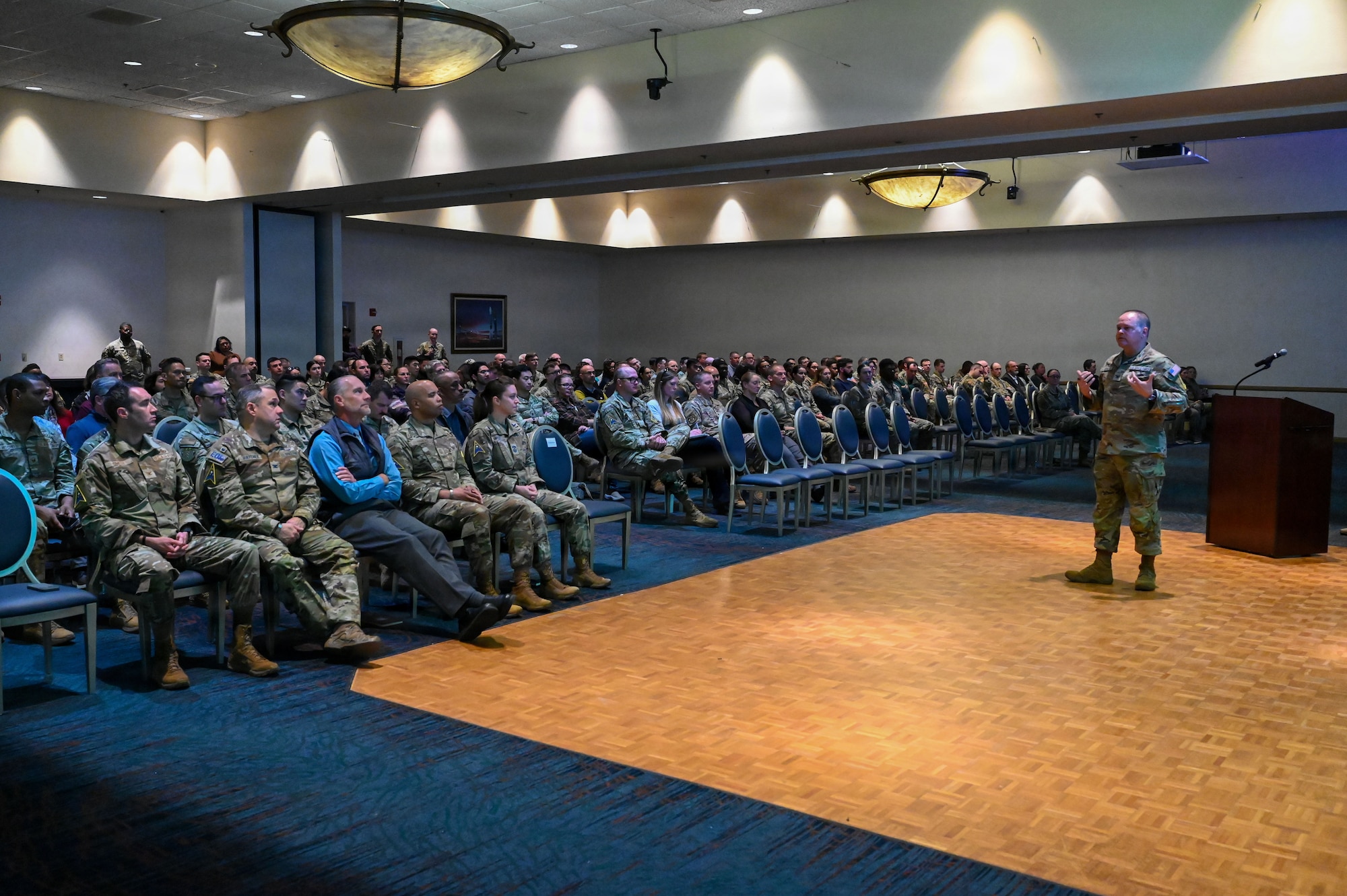 a man stands on a stage and speaks to a crowd