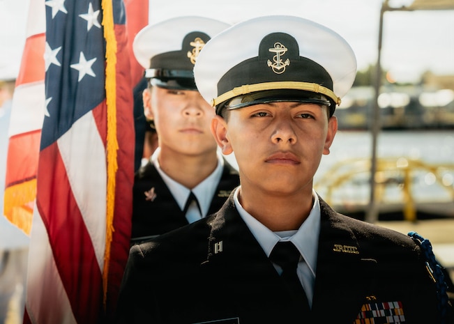 JOINT BASE PEARL HARBOR-HICKAM, Hawaii (Nov. 18, 2025) - Admiral Arthur W. Radford High School Navy Junior Reserve Officer Training Corps parade the colors during a change command ceremony for Los Angeles-class fast-attack submarine USS Columbia (SSN 771), at Joint Base Pearl Harbor-Hickam, Hawaii, Nov. 18, 2025. Columbia is assigned to Submarine Squadron 7 and is capable of supporting various missions, including anti-submarine warfare, anti-surface ship warfare, strike warfare, special operations forces support, and intelligence, surveillance, and reconnaissance. (U.S. Navy photo by Mass Communication Specialist 2nd Class Nicholas Russell)