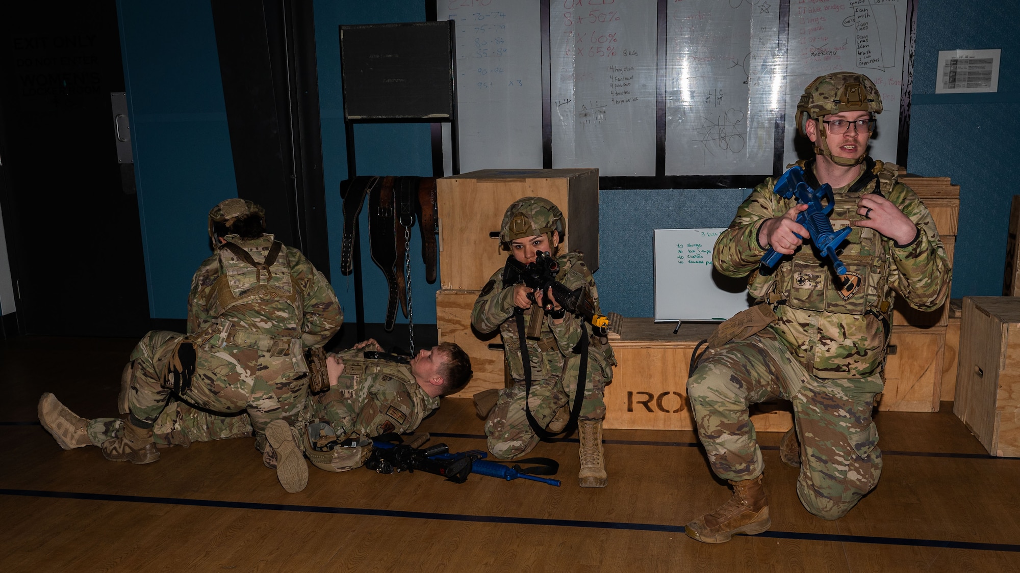 A photo of four military members on the floor in the dark.