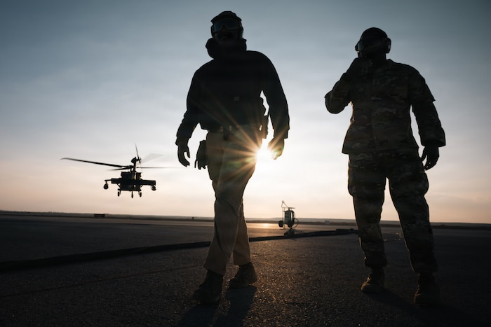 U.S. Air Force Chief Master Sgt. Nicholas Jackson, 332nd Expeditionary Air Base Group senior enlisted leader, right, and Airman 1st Class Samuel Ilet, 332nd Expeditionary Logistics Readiness Squadron fuels distribution operator, walk away as a U.S. Army UH-60 Black Hawk Helicopter takes off in the U.S. Central Command area of responsibility, Dec. 14, 2025. Jackson and Ilet refueled the UH-60 with an R-20 expeditionary refueling system for the first time at the deployed location. (U.S. Air Force photo by Airman 1st Class Jonah Bliss)