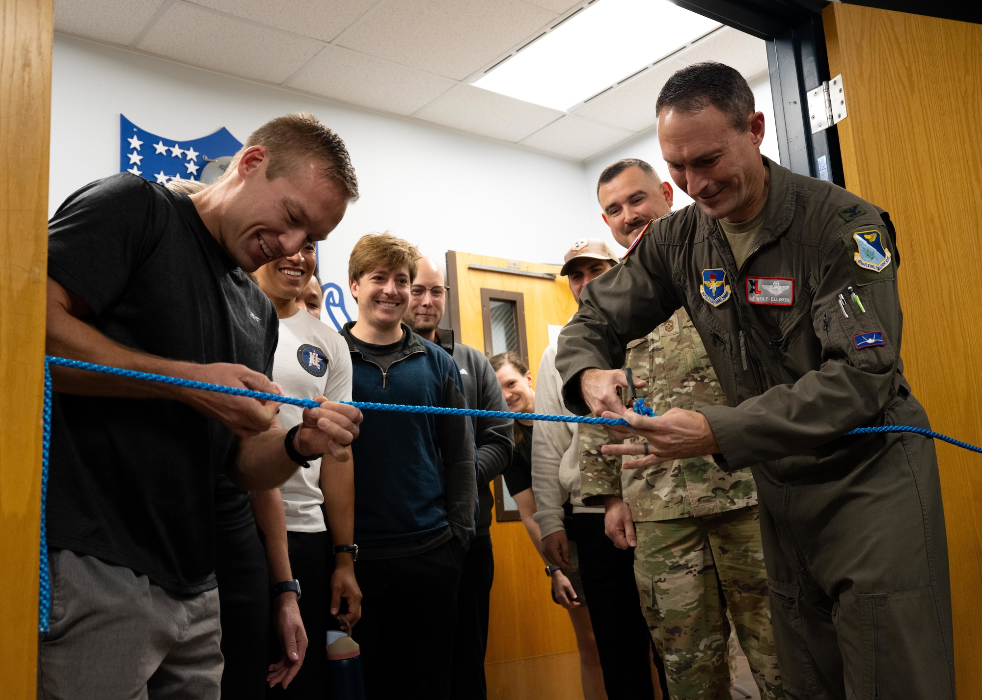 U.S Air Force Col. Tyler Ellison, 47th Flying Training Wing commander, U.S Air Force Capt. Trevor Muzzy (left), Laughlin Air Force Base pilot, and ], U.S Air Force Capt. Trevor Muzzy (left), cut the ribbon during the opening of the Tactical Athlete Center at Laughlin Air Force Base, Texas, Jan. 12, 2025. The new facility supports aircrew readiness through mission-focused strength, recovery, and human performance training. (Air Force photo by Airman 1st Class Harrison Sullivan)