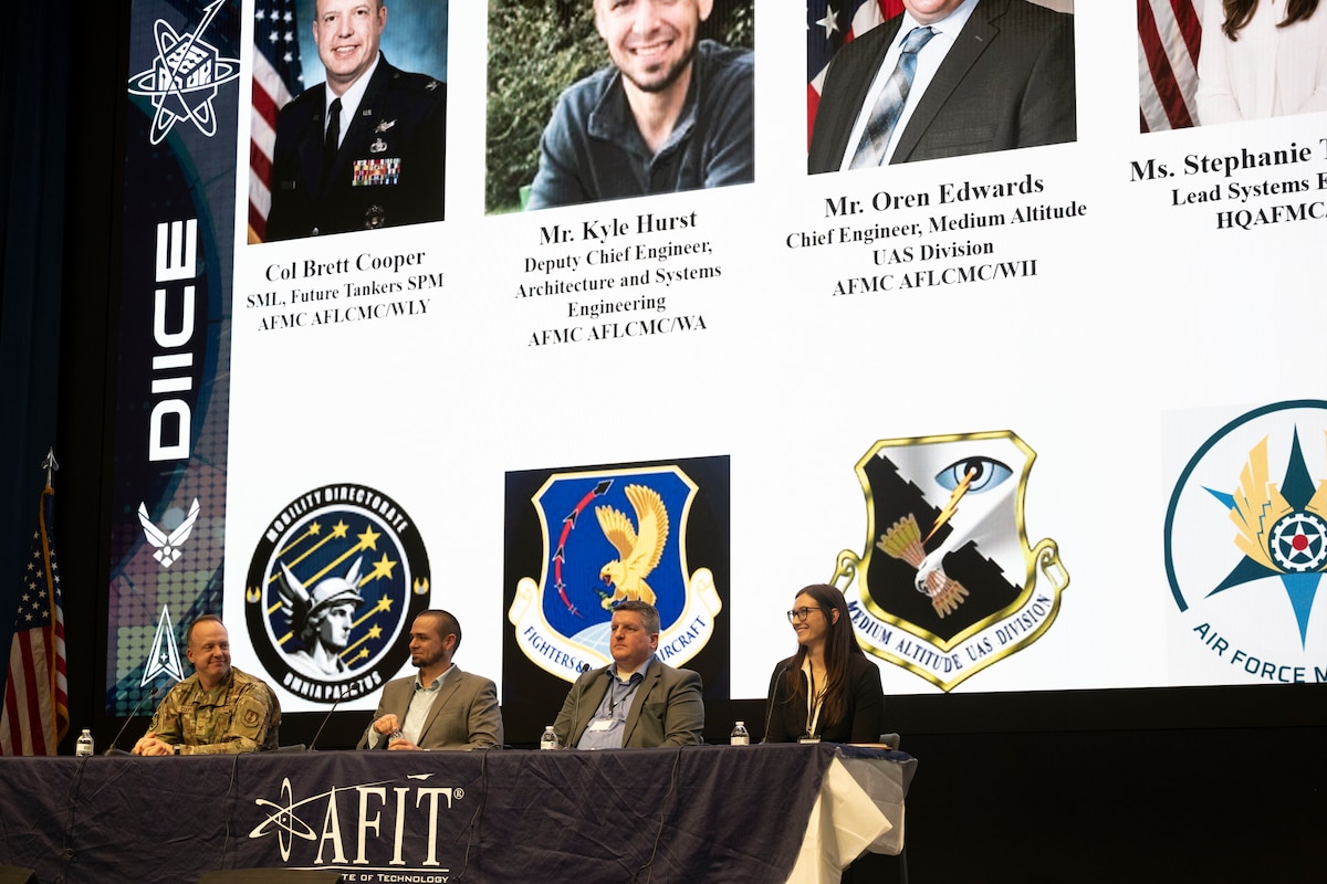 Leader sit on stage at a panel event during a symposium.