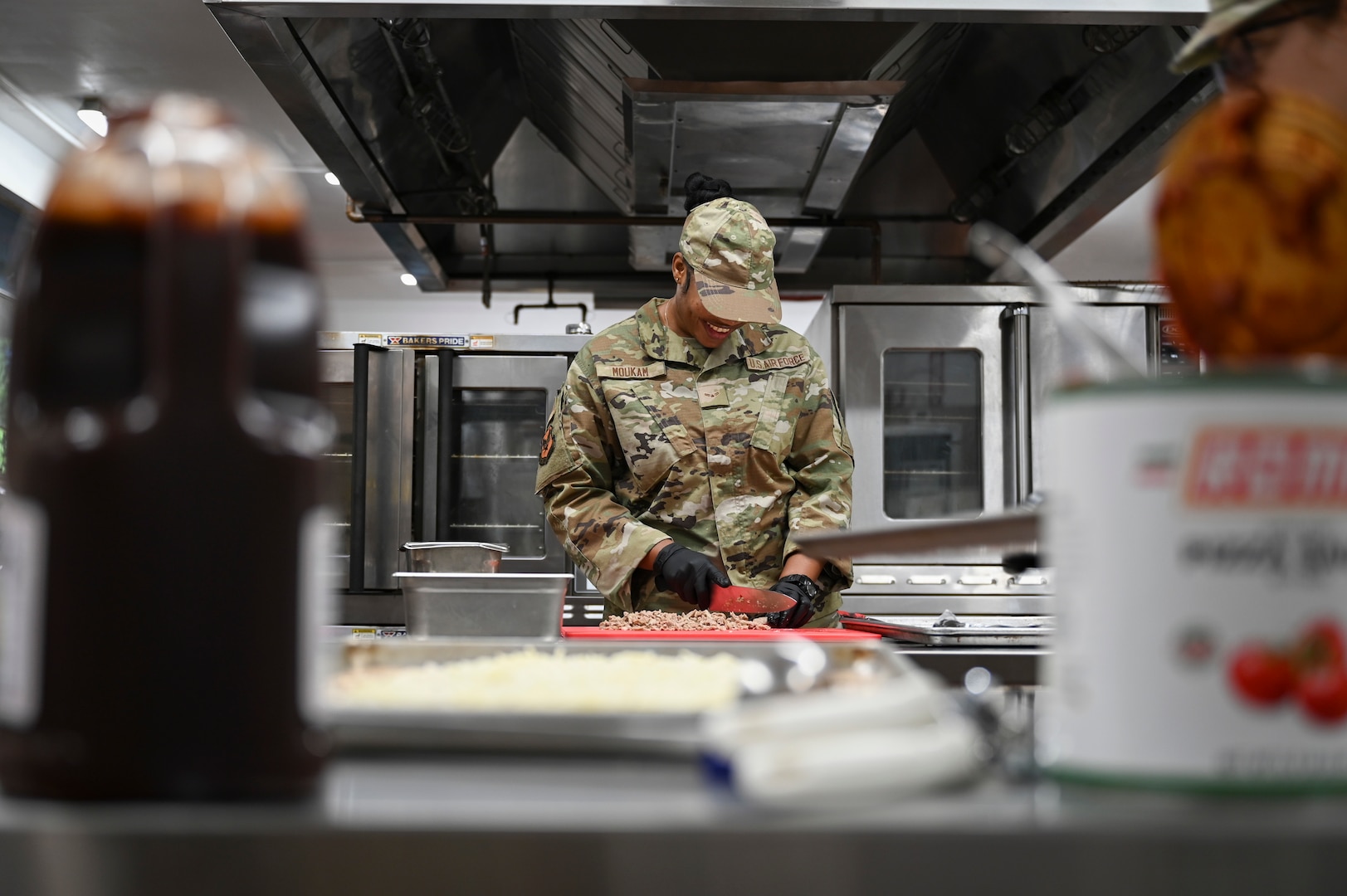 U.S. Air Force Airman 1st Class Sandra Moukam, a services specialist assigned to the 165th Force Support Squadron (FSS), 165th Airlift Wing, Georgia Air National Guard, chops ingredients during lunch preparation at the Savannah Air National Guard Base, Georgia, Oct. 18 2025. The 165 FSS is implementing updates to improve Airmen’s experience at the dining facility, to include new menu items, a modernized dining space, and a cashless payment option. (U.S. Air National Guard photo by Senior Airman Selena Acosta)