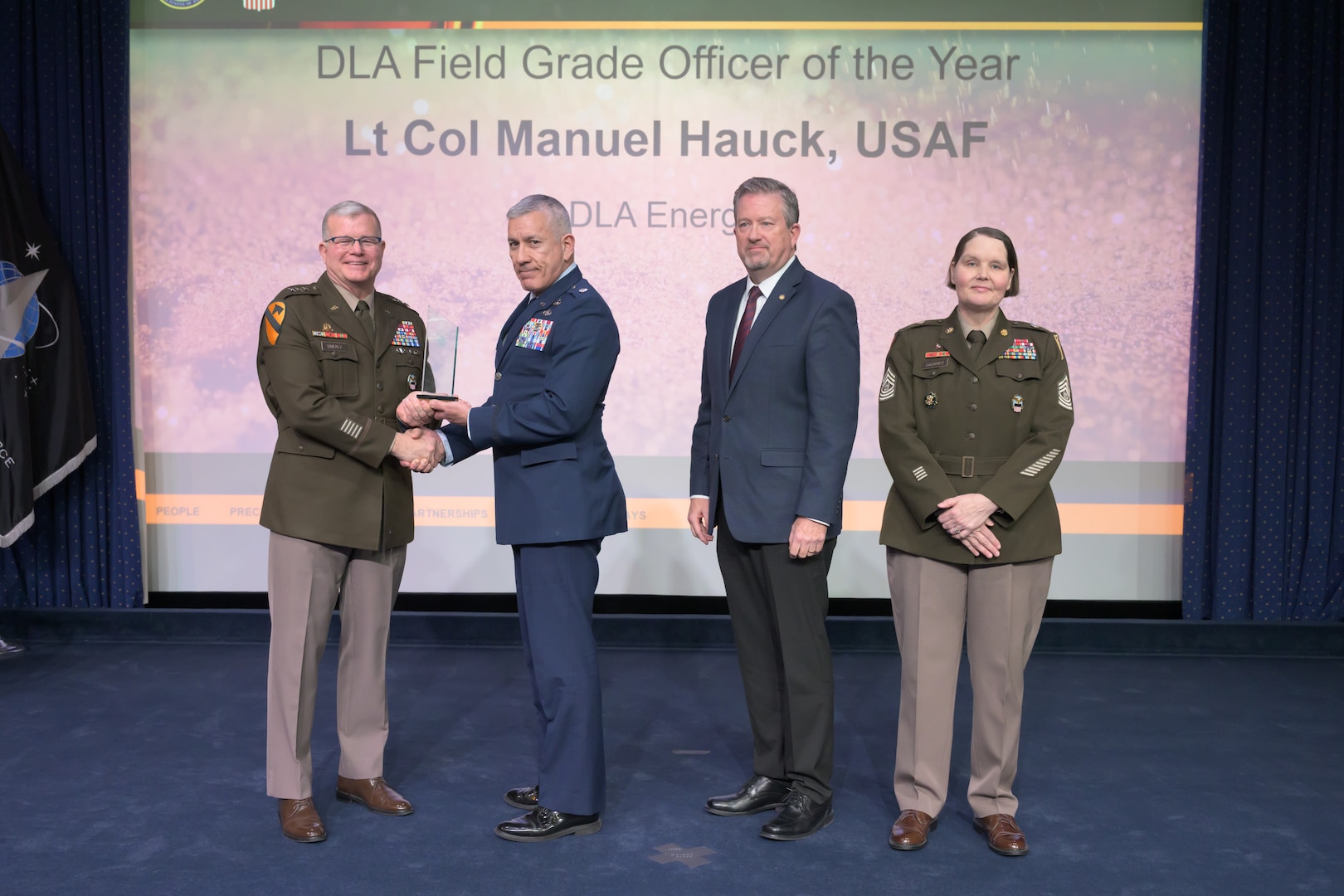 Individuals standing together on a stage.