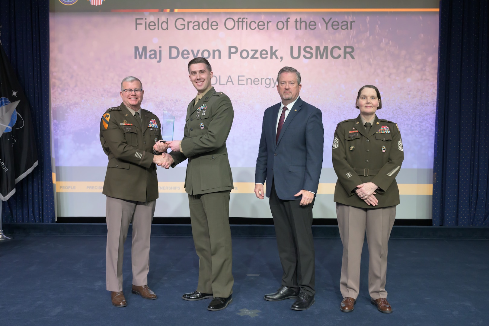 Individuals standing together on a stage.