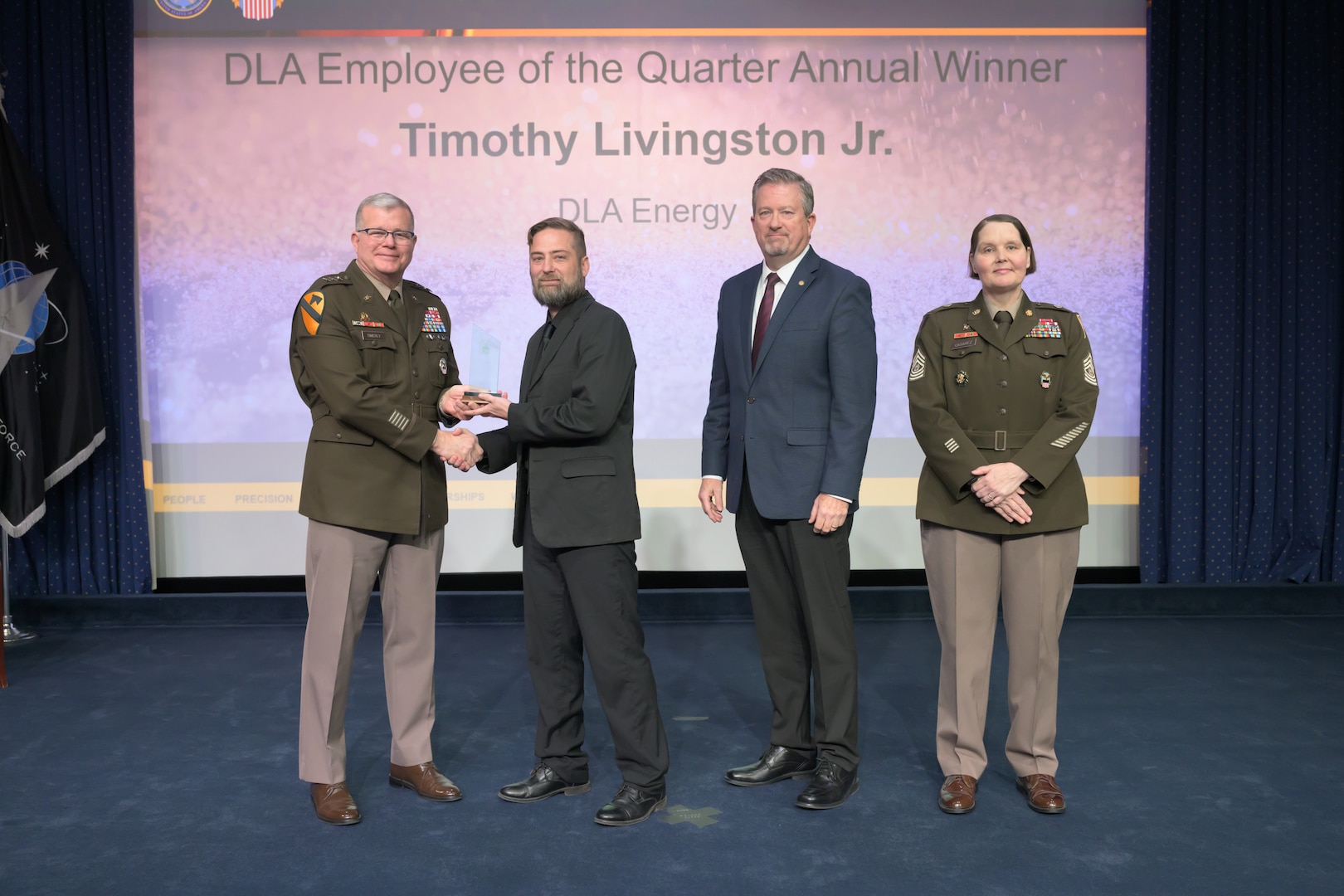 Individuals standing together on a stage.