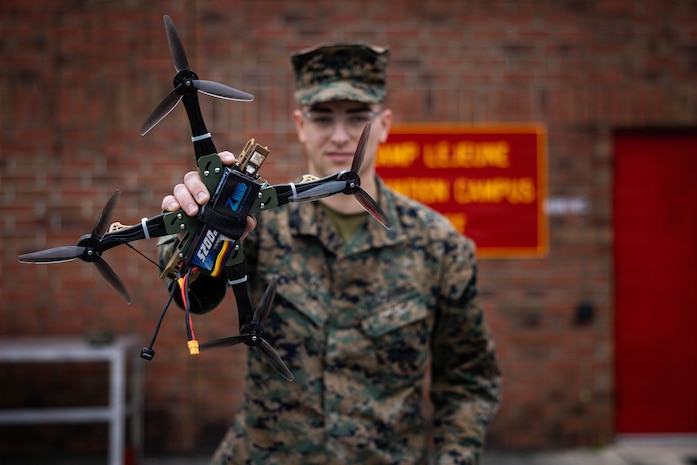 U.S. Marine Corps Sgt. Henry David Volpe, an automotive maintenance technician with 2nd Maintenance Battalion, 2nd Combat Readiness Regiment, 2nd Marine Logistics Group, poses for a photo with the HANX drone he designed at Marine Corps Base Camp Lejeune, North Carolina, Jan. 23, 2026. The HANX is the Marine Corps' first National Defense Authorizing Act-compliant, 3D-printed drone, providing a secure and adaptable aerial platform for the modern warfighter. (U.S. Marine Corps photo by Sgt. Alfonso Livrieri)