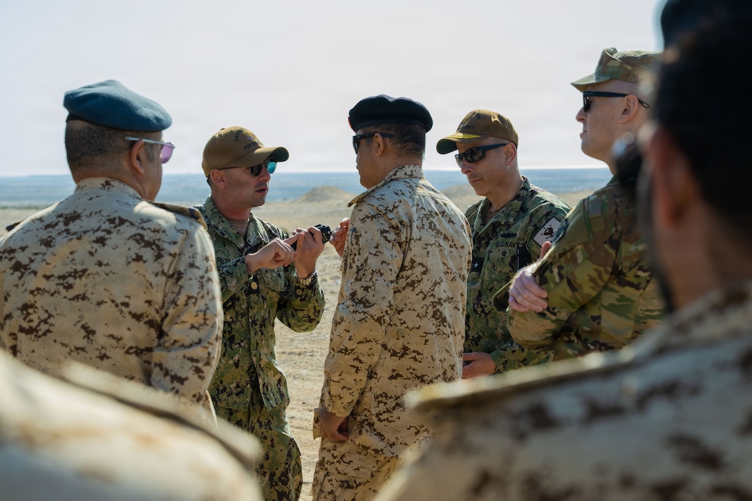 U.S. CENTRAL COMMAND AREA OF RESPONSIBILITY (Jan. 26, 2026) U.S. Navy Lt. Cdr. Michael La Pietra, counter-unmanned aerial systems officer, speaks with Rear Adm. Matthew Kawas, Deputy Commander, U.S. Naval Forces Central Command, and Bahrain Defense Force leadership after a mine-resistant ambush protected (MRAP) vehicle equipped with a mobile-low, slow, small-unmanned aircraft integrated defeat system (M-LIDS) launcher fires a C-UAS at a fixed wing target during a training exercise in Bahrain. This bilateral training between U.S. Naval Forces Central Command and the Bahrain Defense Force improves collaboration and interoperability between the U.S. and Bahrain. (U.S. Navy photo by Mass Communication Specialist 2nd Class Iain Page)