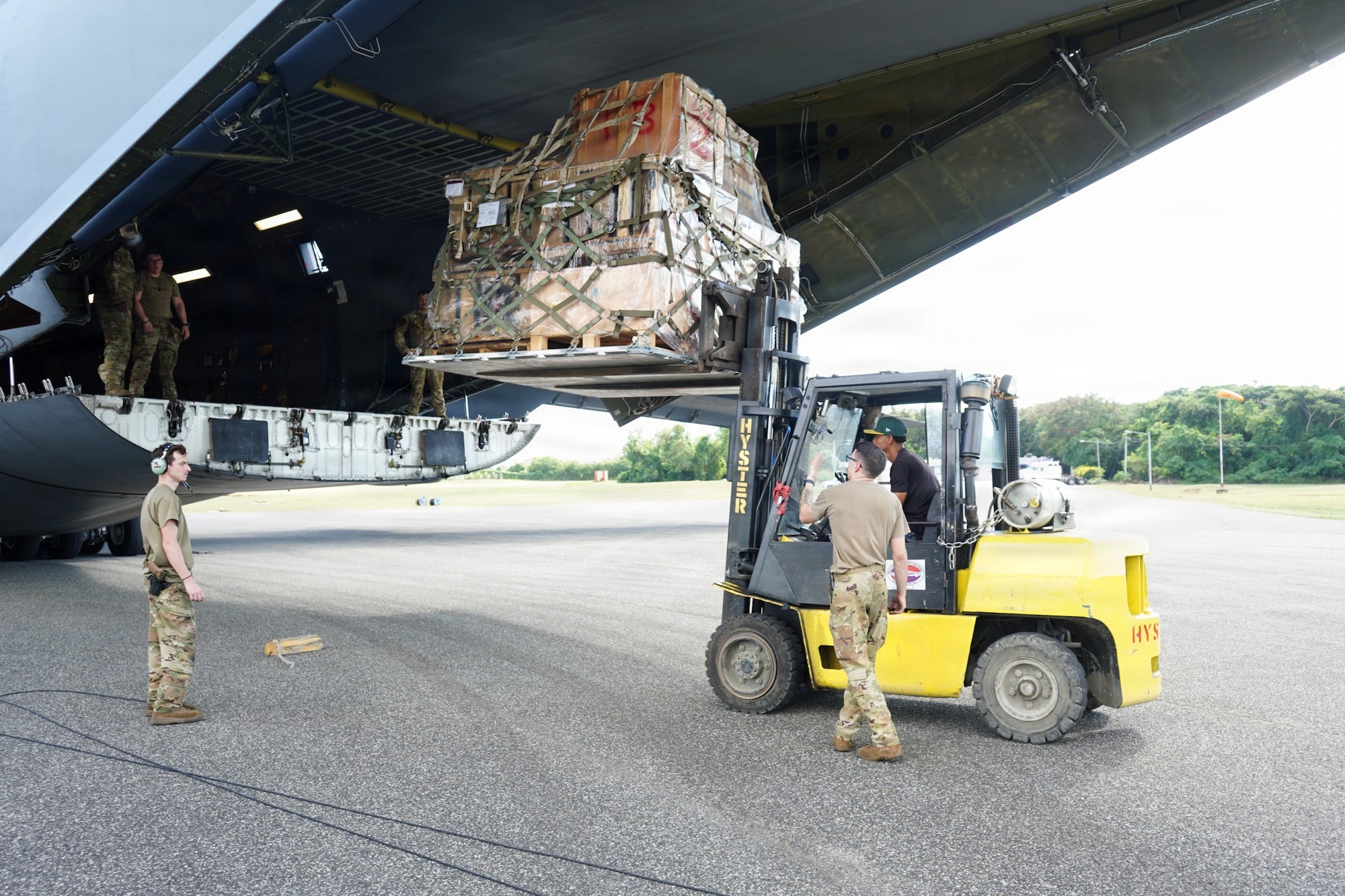 A forklift lifts a pallet loaded with cargo into a Boeing KC-46 Pegasus aircraft.