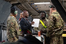 A group of Airmen discuss plans inside of a C-5 Galaxy aircraft.