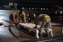Four Airmen set down a piece of a ramp.