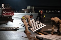 Airmen set down a piece of a ramp.