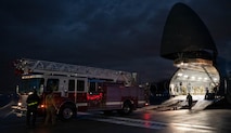 A firetruck backs into a C-5 Galaxy aircraft