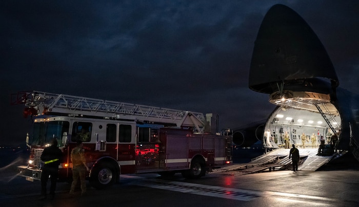 A firetruck backs into a C-5 Galaxy aircraft