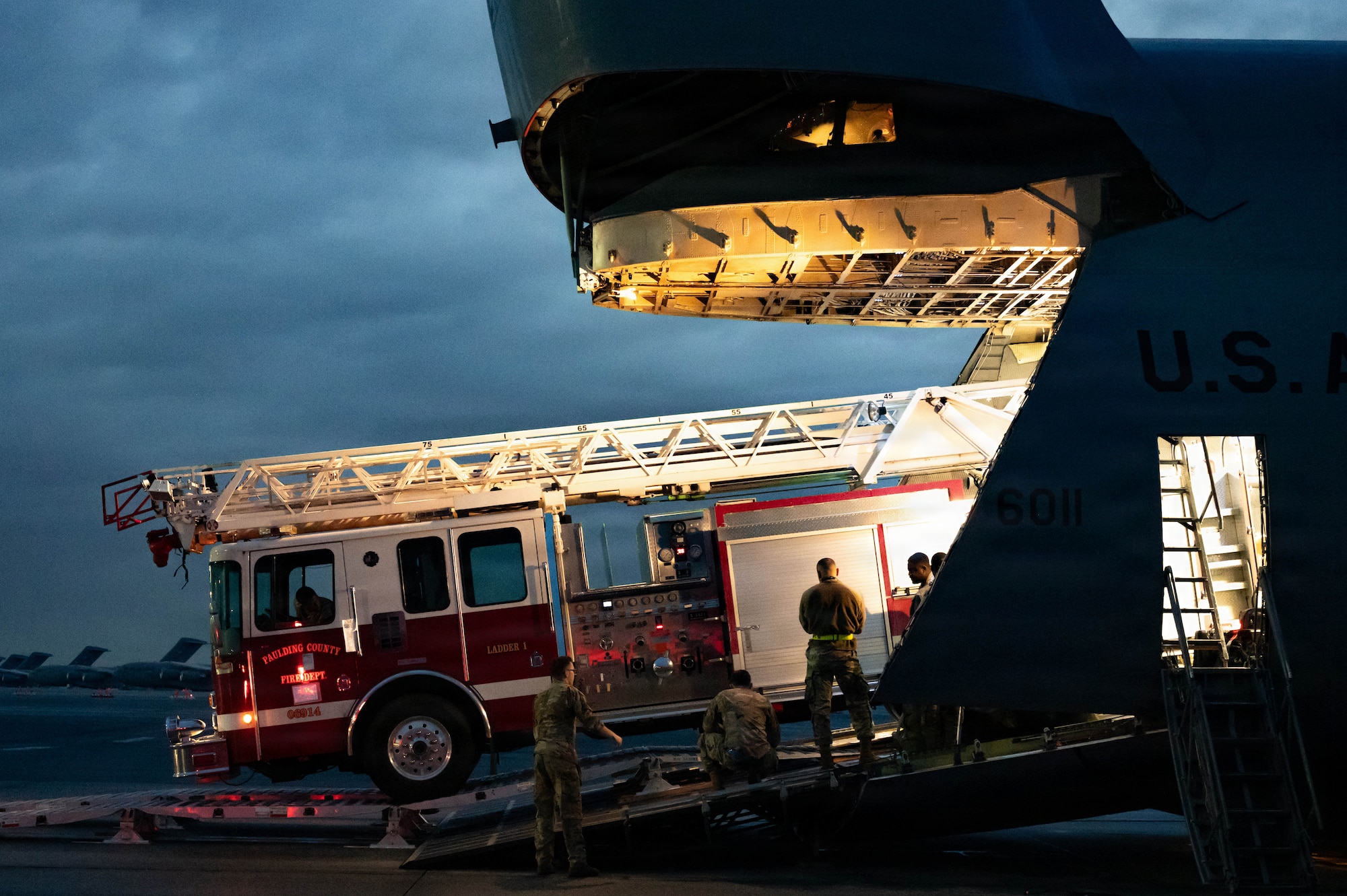A firetruck backs into a C-5 Galaxy aircraft.