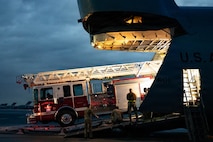 A firetruck backs into a C-5 Galaxy aircraft.