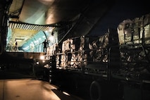 An aircraft loader preparing to unload cargo into a C-5 Super Galaxy.