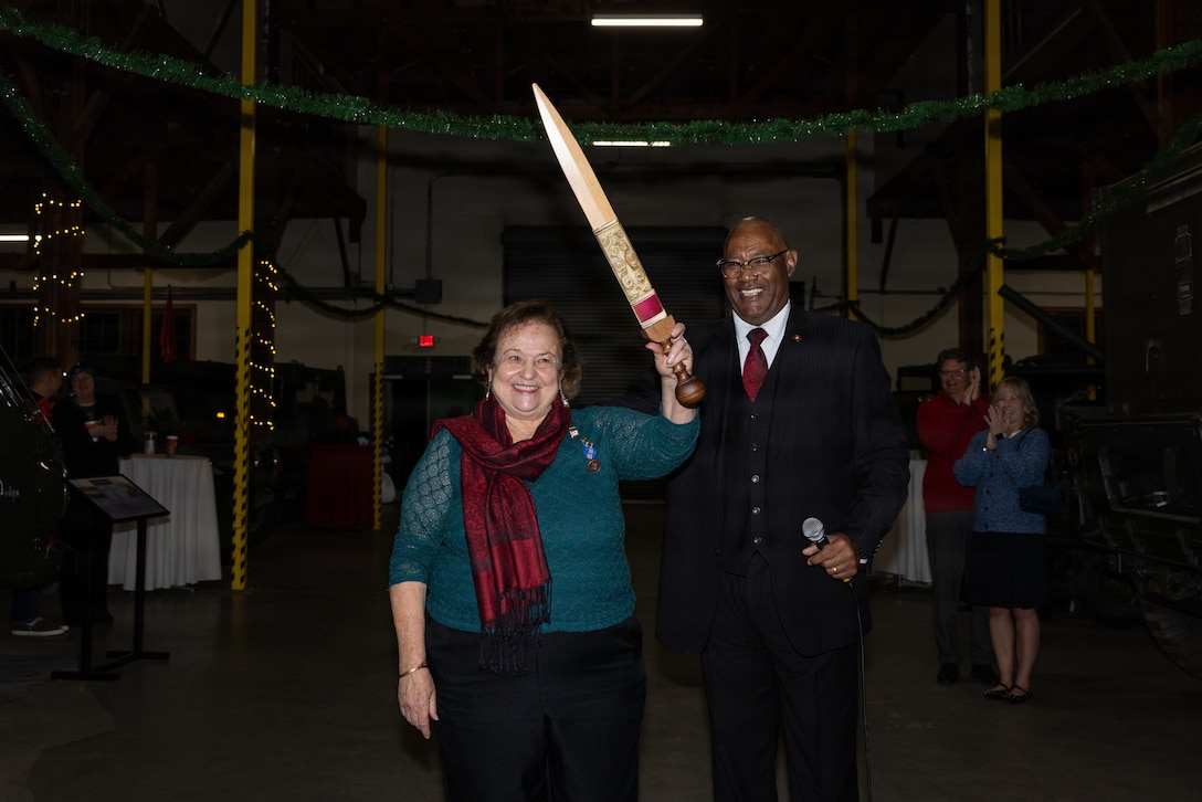 Alice "Faye" Jonason holds up decorative wooden sword for the crowd to see.