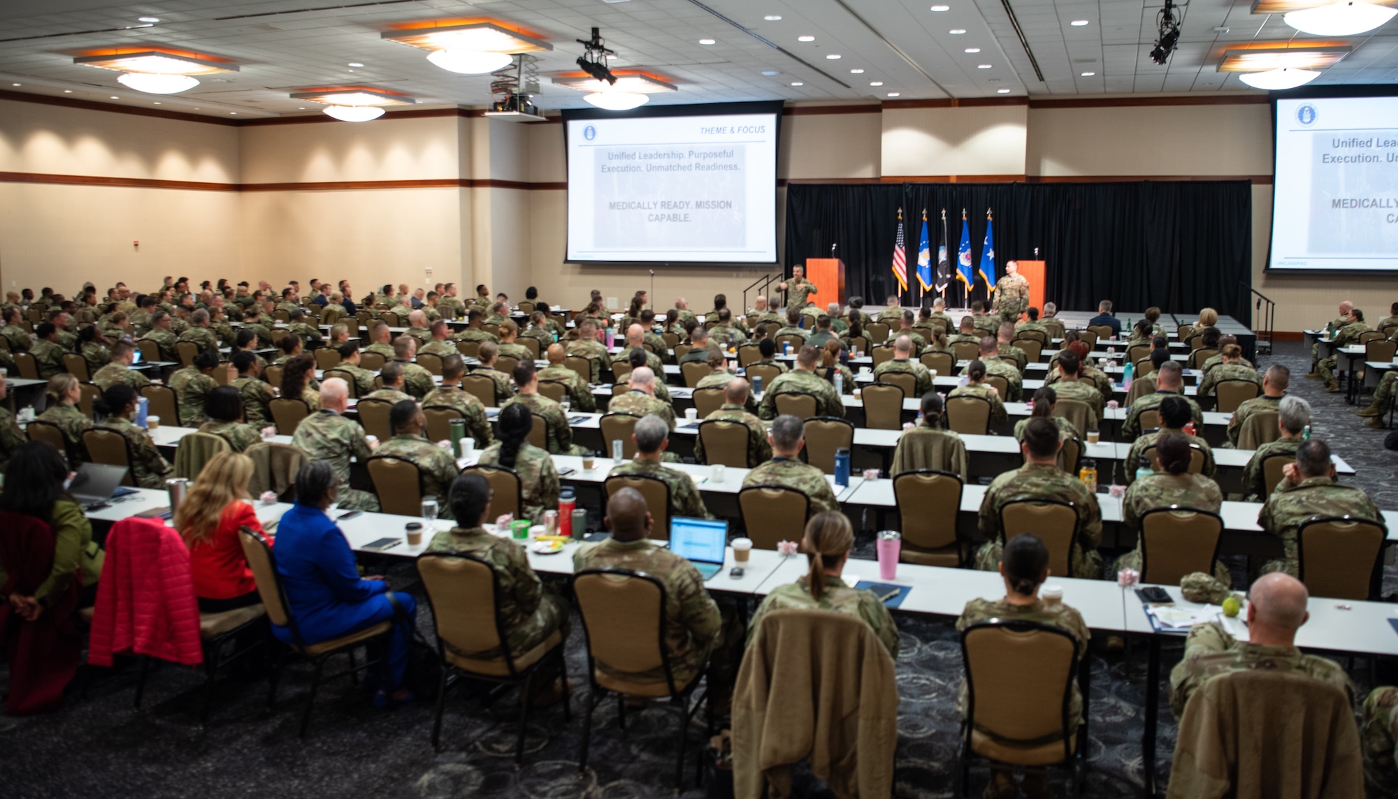 Image of a group in a large room listening to presentations.
