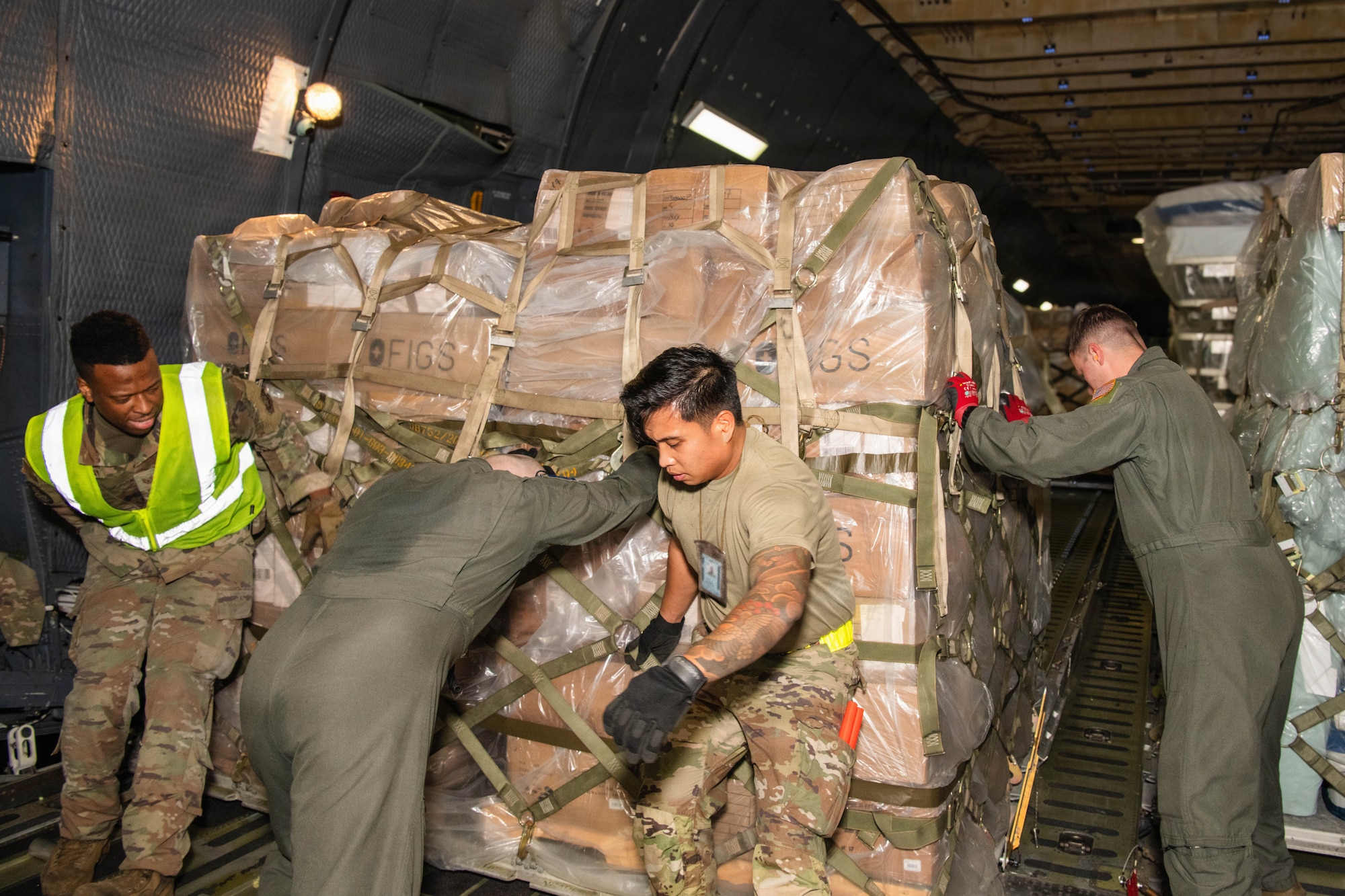 Four Airmen load a pallet into a C-5 Galaxy aircraft.