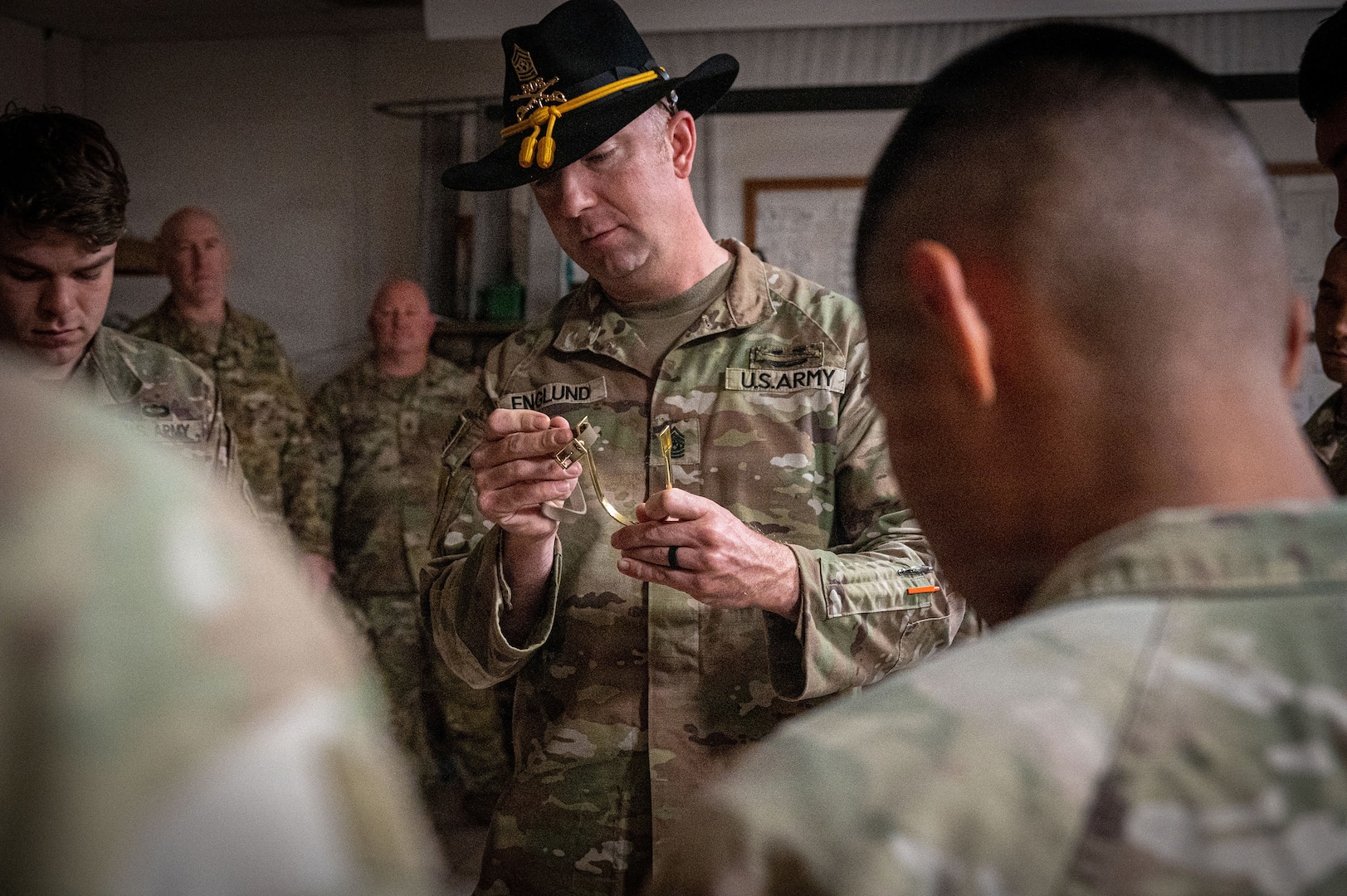 U.S. Army Command Sgt. Maj. Tim Englund, a master spur holder assigned to the 303rd Cavalry Regiment, Washington National Guard, inspects a gold spur during a ceremony at Camp Lemonnier, Djibouti, Jan. 9, 2026.