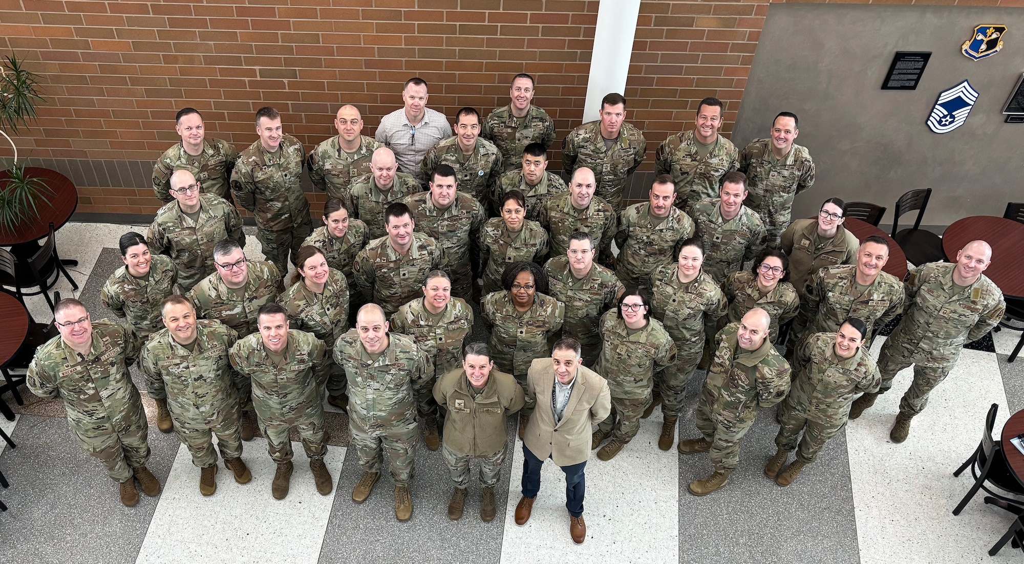557th WW leaders pose for a photo where they stand looking upwards at the person taking the photo