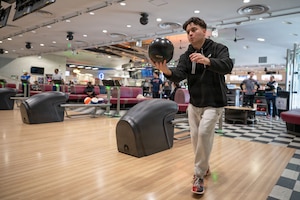 A person rolls a bowling ball