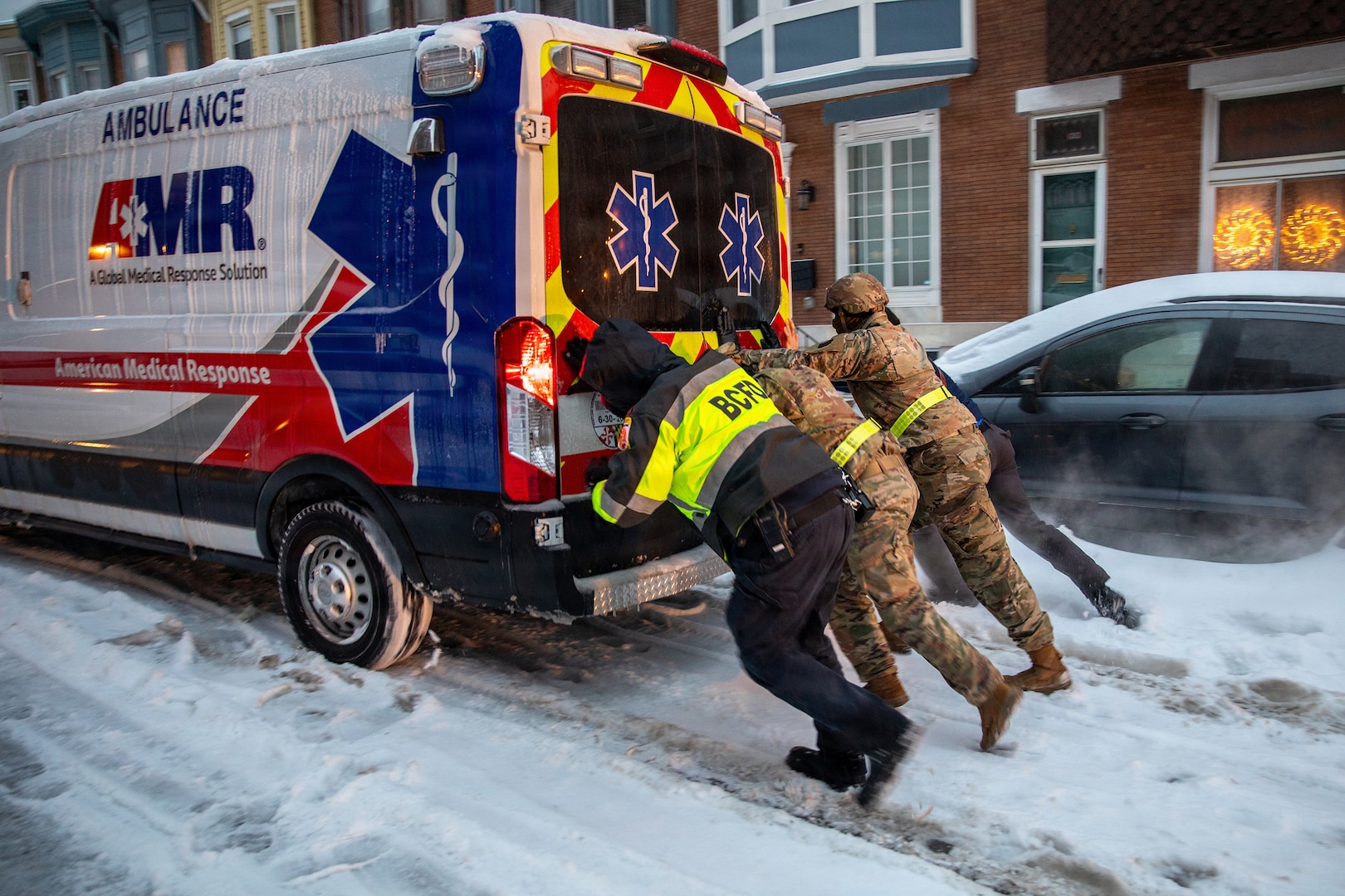 Maryland Army National Guard Soldiers from 1st Battalion, 175th Infantry Battalion and paramedics from Old Town Fire Station push an ambulance out of the snow in Baltimore, Jan. 25, 2026.