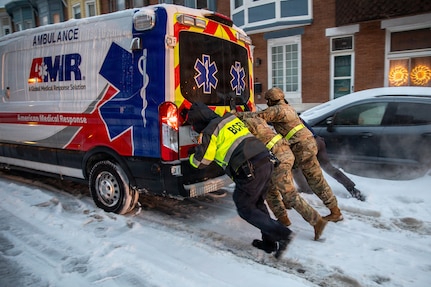 Maryland Army National Guard Soldiers from 1st Battalion, 175th Infantry Battalion and paramedics from Old Town Fire Station push an ambulance out of the snow in Baltimore, Jan. 25, 2026.