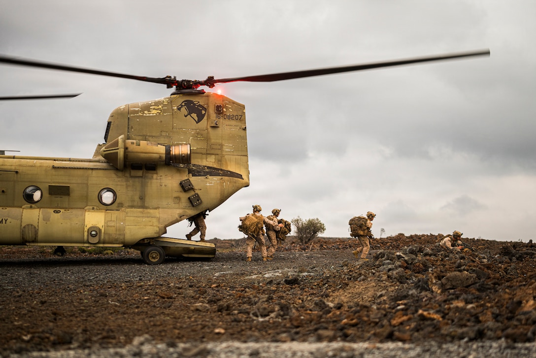U.S. Marines with 3rd Littoral Combat Team, 3rd Marine Littoral Regiment, 3rd Marine Division, offload from U.S. Army CH-47 Chinook helicopters during an air insert training exercise at Pohakuloa Training Area, Hawaii, Jan. 21, 2026.