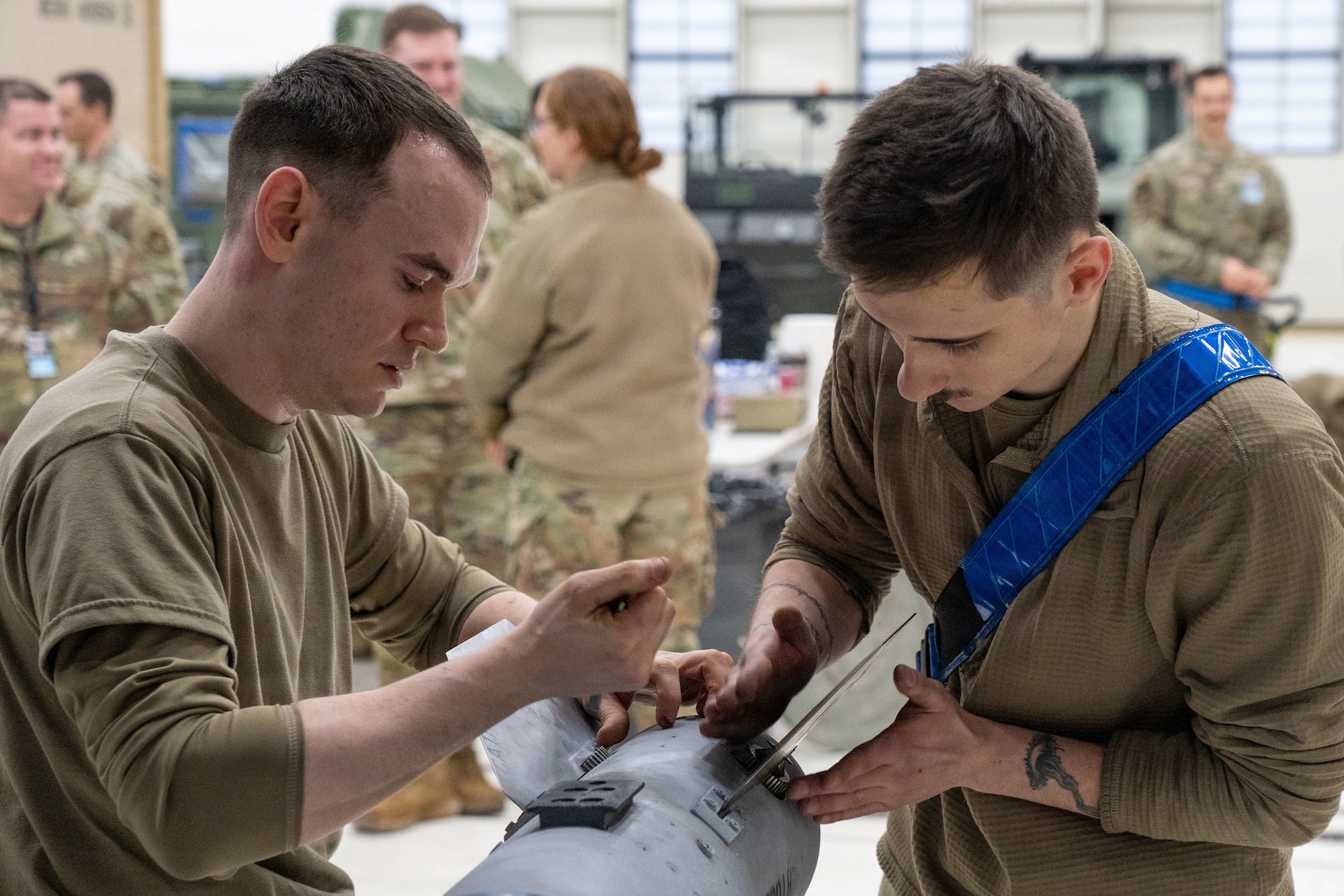 U.S. Air Force Staff Sgt. Anthony Godlewski (left) and Airman 1st Class Aubrey Shifflett, Airmen assigned to the 525th Fighter Generation Squadron, assemble an AIM-120 AMRAAM during the  annual Mission Generation Competition at Joint Base Elmendorf-Richardson, Alaska, Jan. 9, 2026.