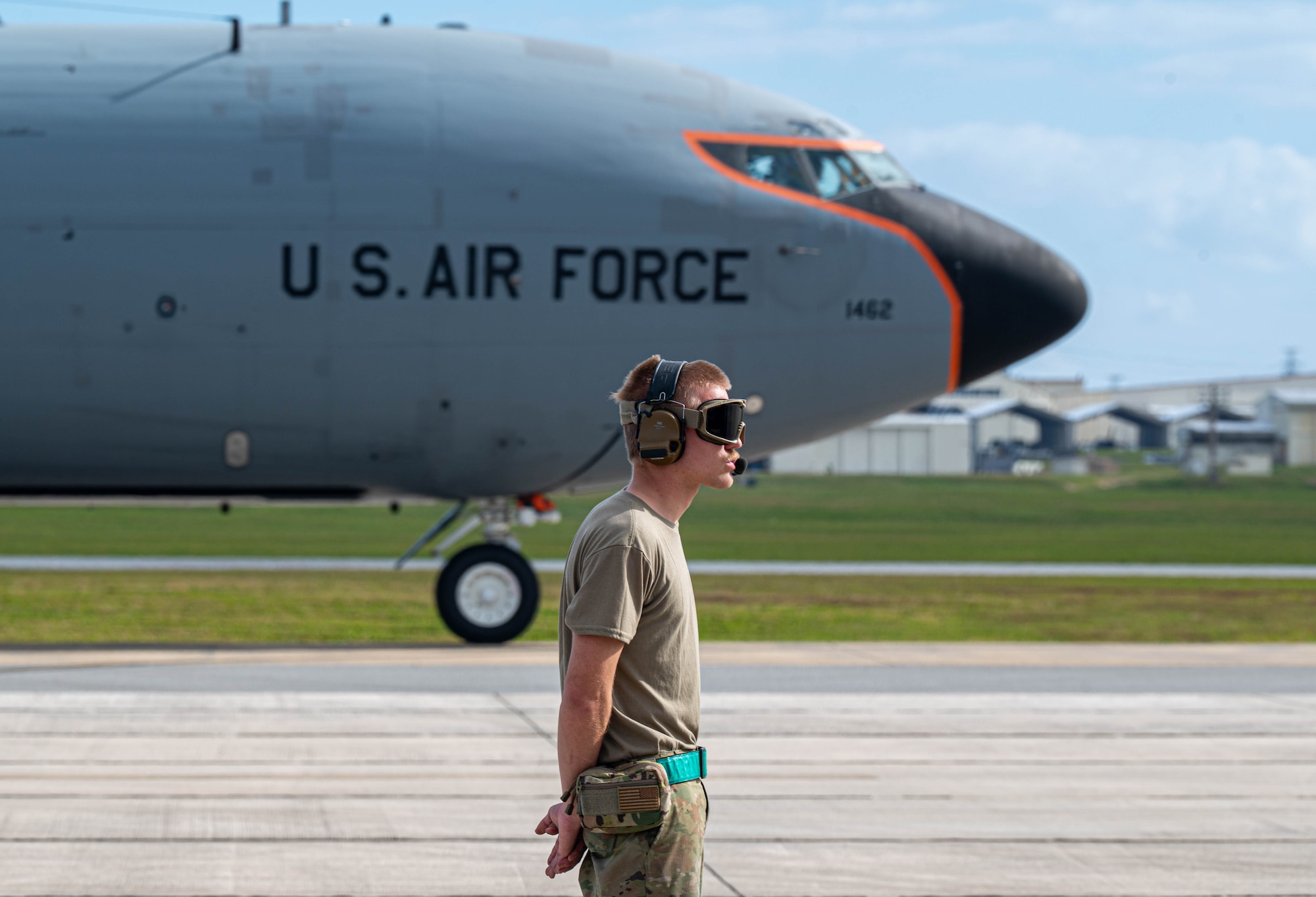 U.S. Air Force Airman 1st Class Conner Cobbs, 33rd Rescue Squadron crew chief, marshals an HH-60W Jolly Green II during flight operations as a KC-130 Stratotanker taxis in the background at Kadena Air Base, Japan, Jan. 12, 2026. The 18th OSS Weather Flight supports air operations across the Indo-Pacific, providing forecasts used by both military and commercial aviation partners. (U.S. Air Force photo by Senior Airman Jamal Berry II)