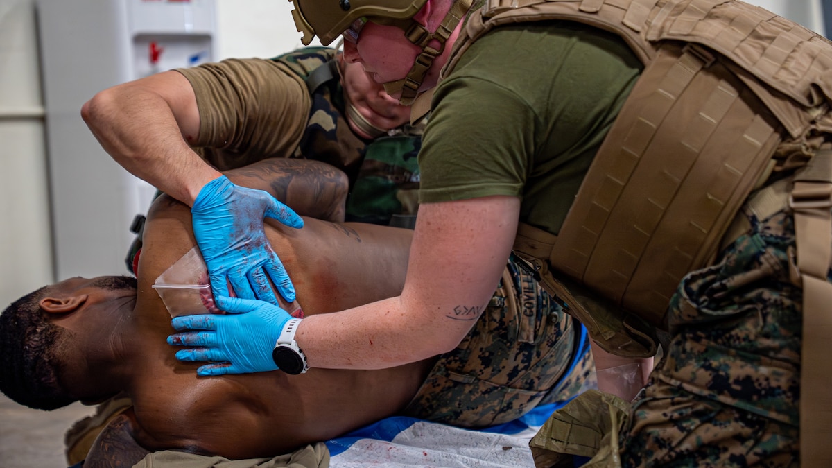 USMC Marines apply pressure to a simulated wound.