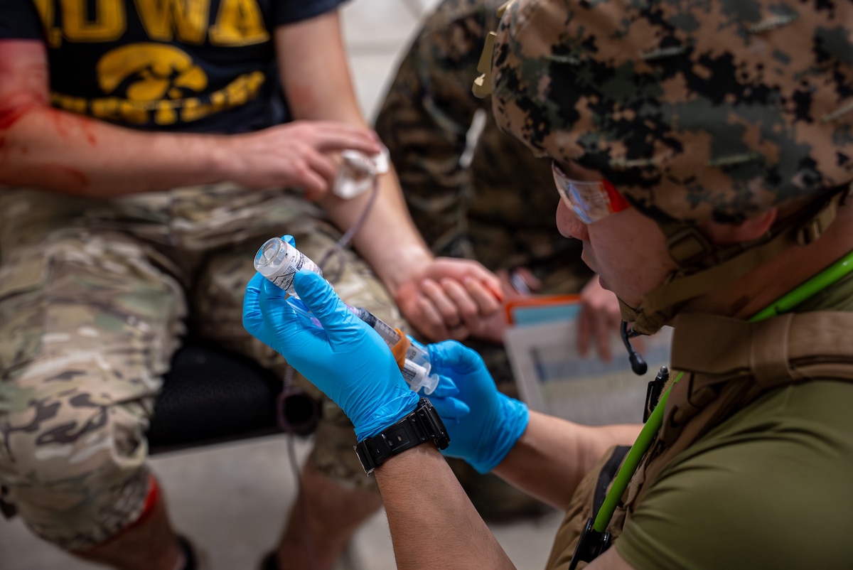A USMC Marine draws tranexamic acid form a vial.