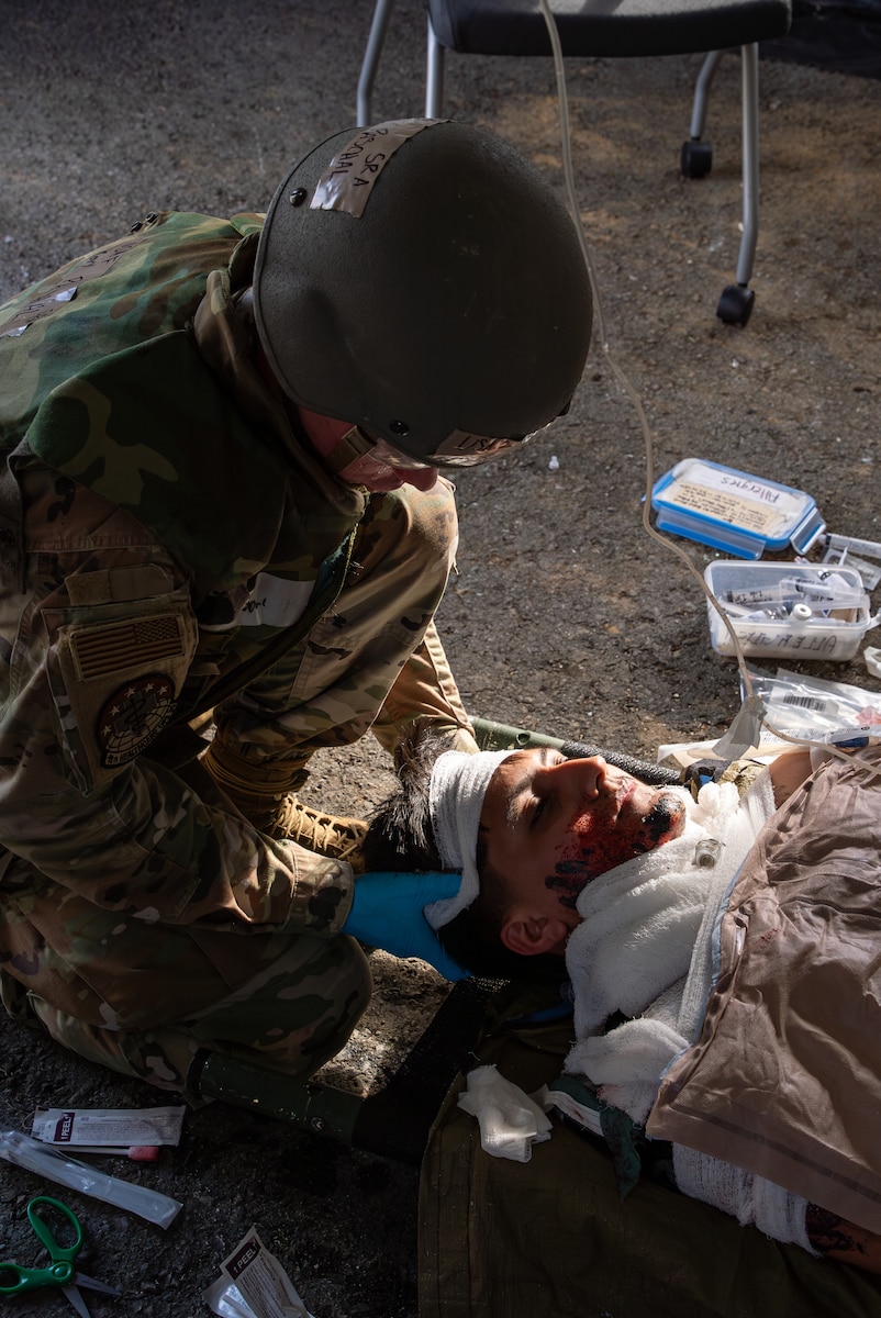 A USAF Airman dresses a headband onto a simulated patient.