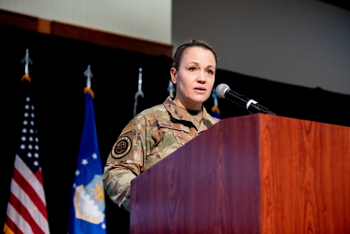 Image of an Airman talking at a podium.