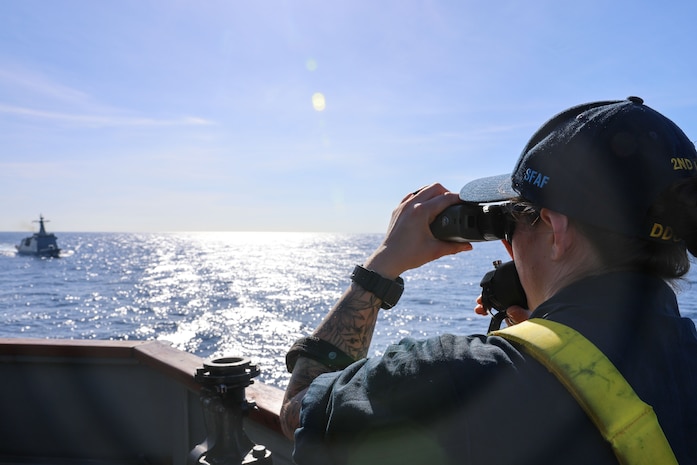 U.S. Navy Ensign Anna Drinkert measures the distance between Arleigh Burke-class guided-missile destroyer USS John Finn (DDG 113) and Philippine Coast Guard Gabriela Silang-class frigate BRP Gabriela Silang (8301) during a replenishment-at-sea drill during the Maritime Cooperative Activity (MCA) in the Philippines’ Exclusive Economic Zone, Jan. 25, 2026.