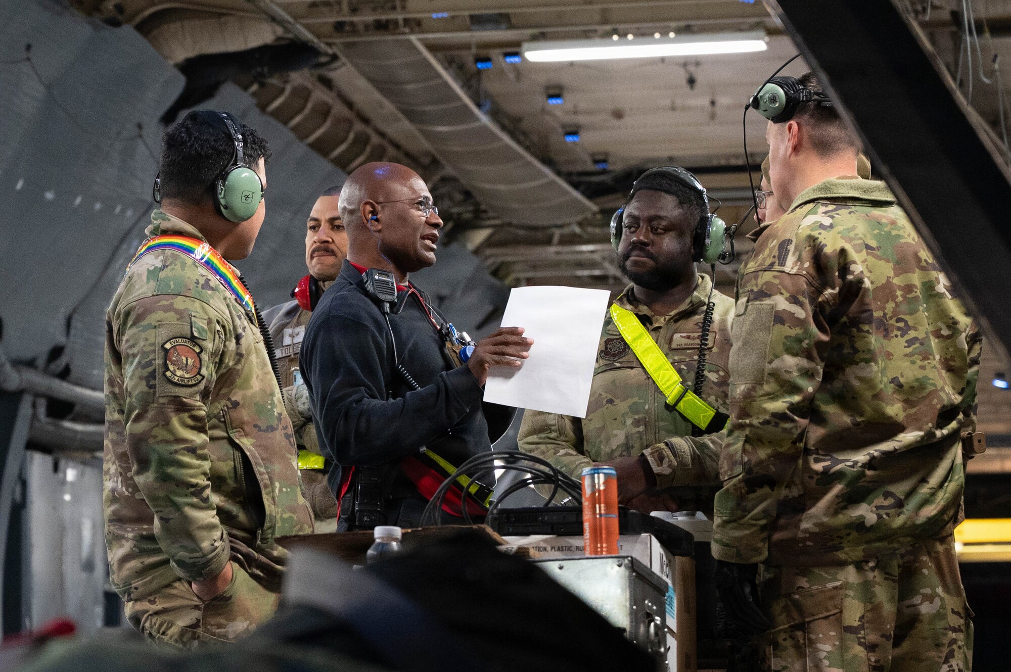 A group of Airmen discuss plans inside of a C-5 Galaxy aircraft.