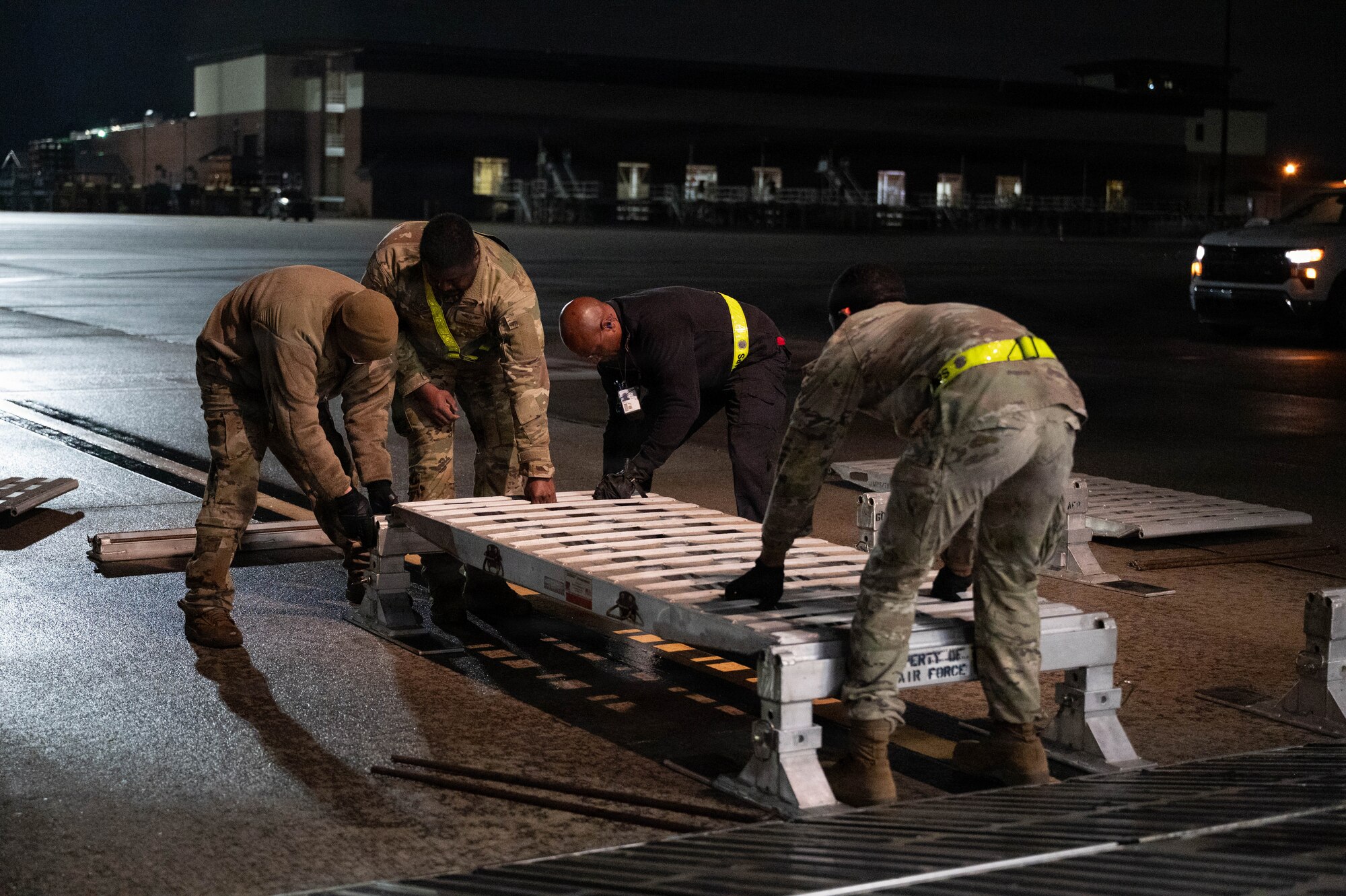 Four Airmen set down a piece of a ramp.