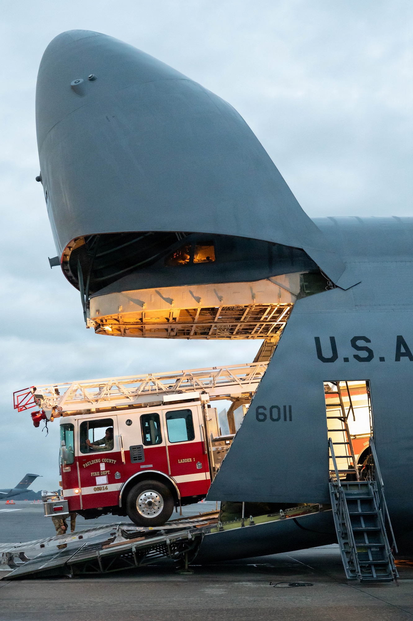 A firetruck backs up a ramp into into an open C-5 Galaxy aircraft
