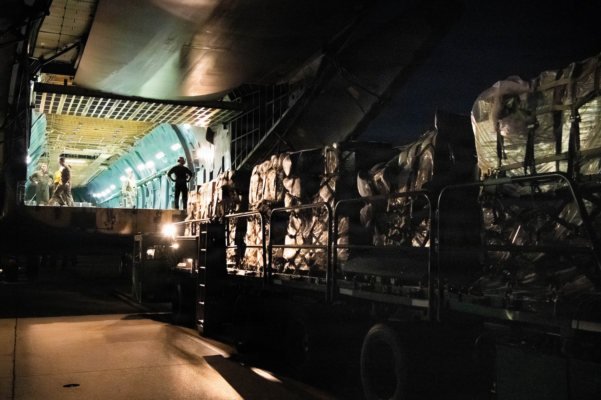 An aircraft loader preparing to unload cargo into a C-5 Super Galaxy.