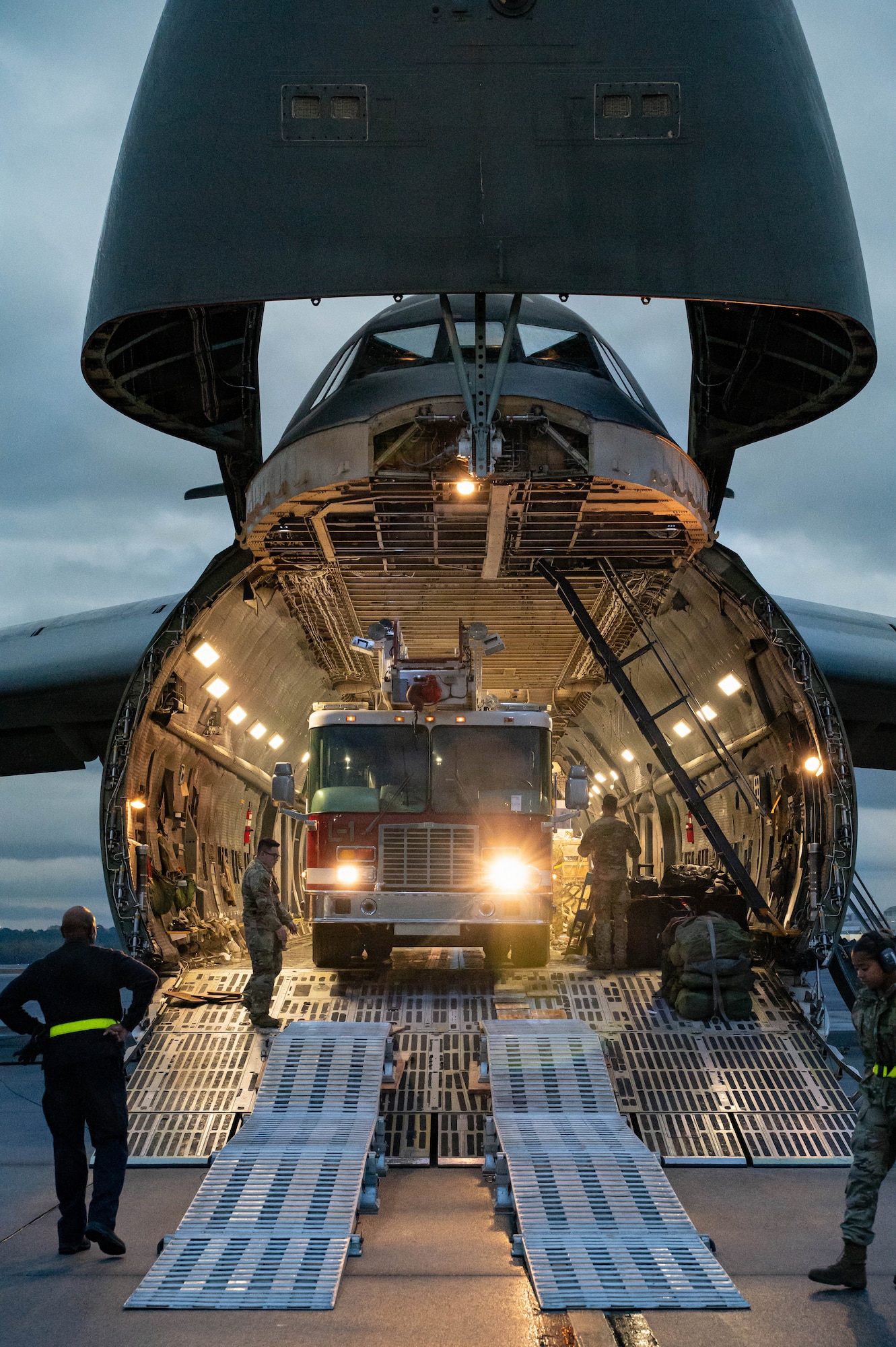 A firetruck backs into a C-5 Galaxy aircraft